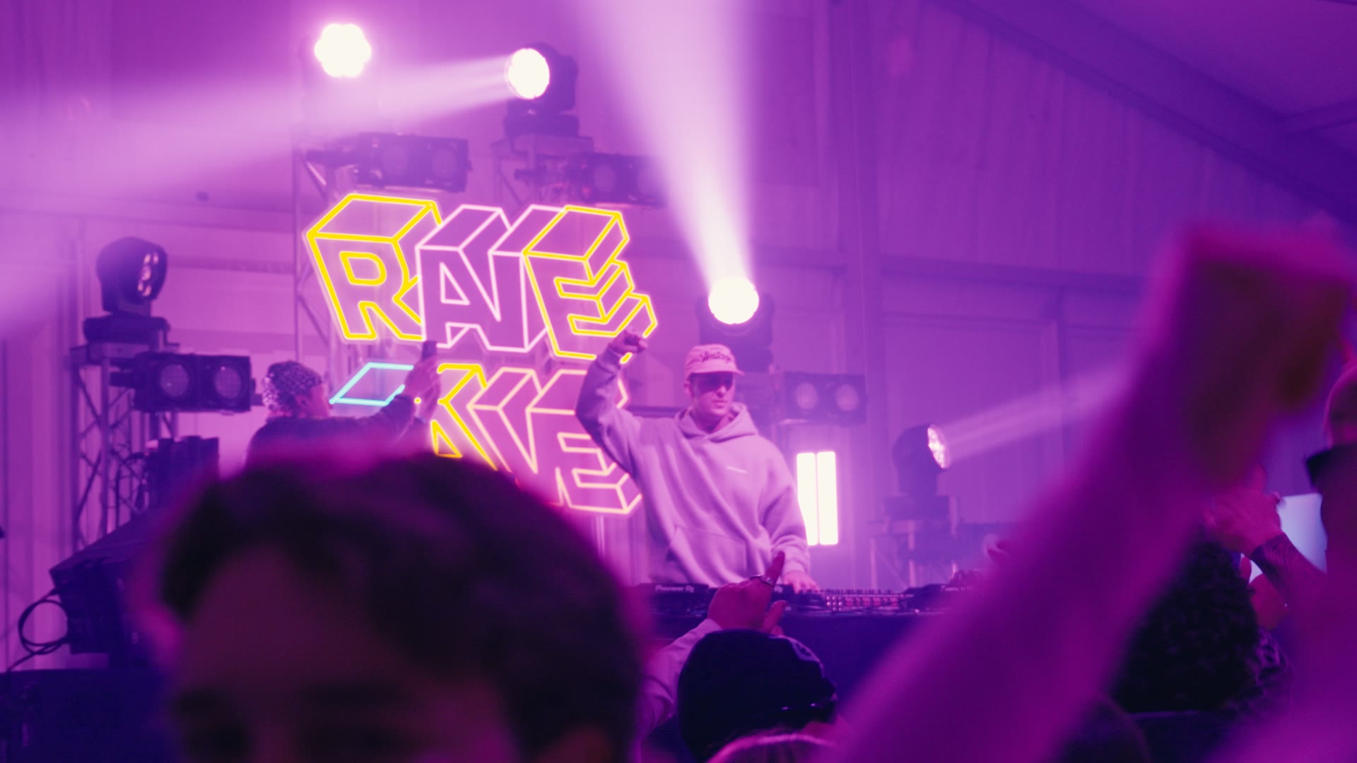 DJ performing beneath purple lights at a live event